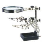 Elektroniikan juotosapuri suurennuslasilla ja pidikkeellä